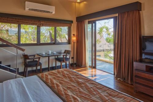 a hotel room with a bed and a television and a table at Two Seasons Coron Island Resort in Coron