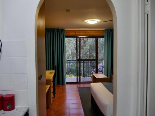 a hotel room with a bed and a window at Tannum On The Beach Motel in Tannum Sands