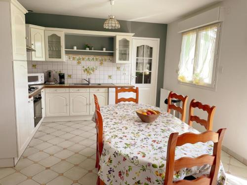 une cuisine avec une table avec un bol de fruits dessus dans l'établissement Gîte familial et chaleureux avec jardin clos, garage, et proche de Blois, animaux bienvenus - FR-1-491-446, à Orchaise