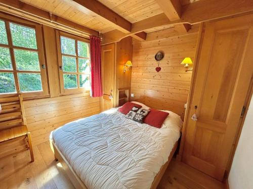 une chambre avec un lit dans une pièce en bois dans l'établissement Appartement 3 Pièces + Mezzanine, 7 couchages, 2 Balcons, Parking - FR-1-597-177, à Combloux