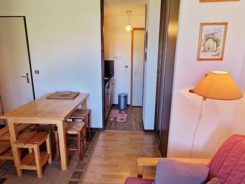 un salon avec une table en bois et une chambre avec un couloir dans l'établissement Charmant appartement 2 pièces aux pieds des pistes, exposition sud/ouest, Plagne Montalbert - FR-1-755-16, à Aime La Plagne