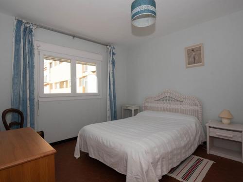 une chambre avec un lit blanc et une fenêtre dans l'établissement Location T2 avec piscine, proche plage, tennis, et garage fermé - Le Lavandou - FR-1-803-51, au Lavandou