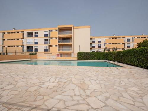 une piscine devant un immeuble dans l'établissement Location T2 avec piscine, proche plage, tennis, et garage fermé - Le Lavandou - FR-1-803-51, au Lavandou