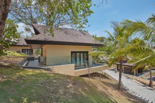a house on a hill with palm trees at Two Seasons Coron Island Resort in Coron
