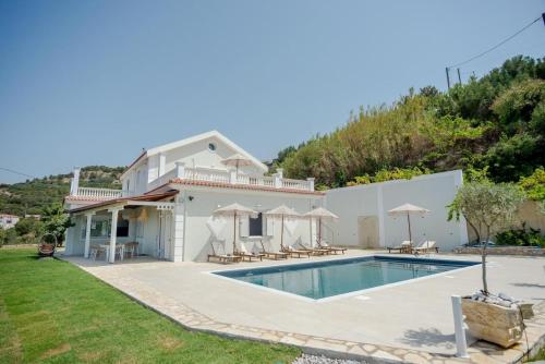 a villa with a swimming pool and a house at Pantheon Villa Svoronata in Svoronata