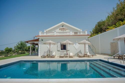 a villa with a swimming pool in front of a house at Pantheon Villa Svoronata in Svoronata