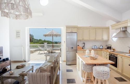 a kitchen with a table and a refrigerator at Pantheon Villa Svoronata in Svoronata