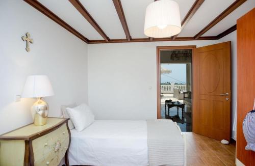 a bedroom with a bed and a table with a lamp at Pantheon Villa Svoronata in Svoronata