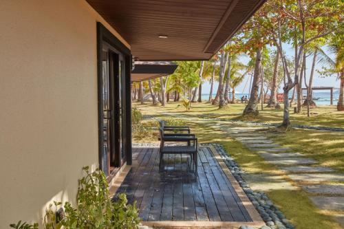 a bench sitting on the porch of a building at Two Seasons Coron Island Resort in Coron
