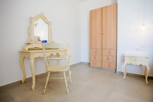 a dressing table with a mirror and a chair at Pantheon Villa Svoronata in Svoronata