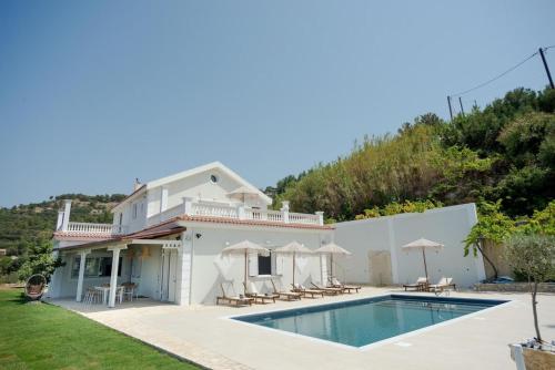a villa with a swimming pool and a house at Pantheon Villa Svoronata in Svoronata