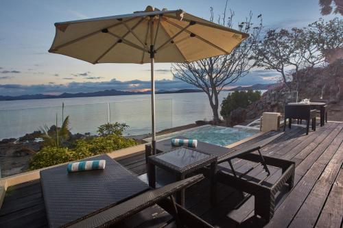 a patio with an umbrella and a table and chairs at Two Seasons Coron Island Resort in Coron