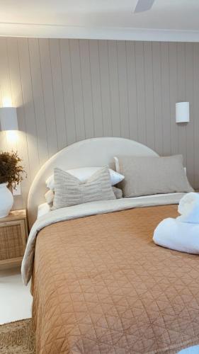 a bedroom with a large bed with pillows on it at HOME ByCoastalRoad in Toukley