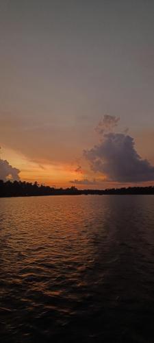 a sunset over a large body of water at Prakruthi Residency Munroeisland in Munroe Island