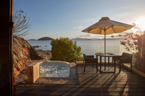 a patio with an umbrella and a table with chairs at Two Seasons Coron Island Resort in Coron
