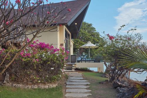 a house with a pathway leading up to it with flowers at Two Seasons Coron Island Resort in Coron