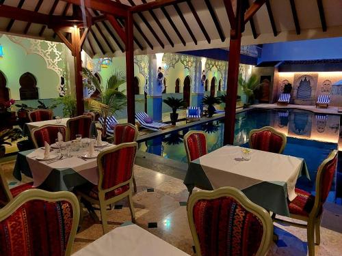 a restaurant with a swimming pool and tables and chairs at Blue Garden Boutique Hotel in Jepara