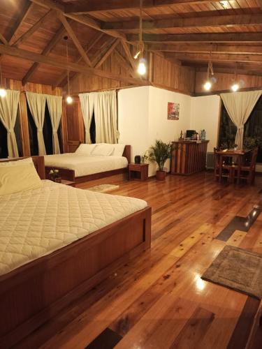 a large bedroom with two beds and wooden floors at La Casa de Martin in Baños