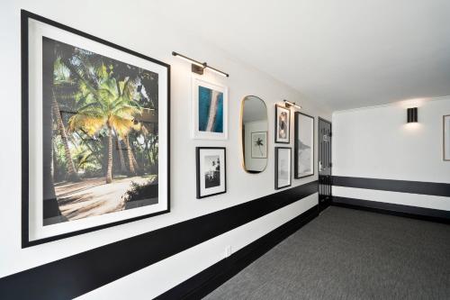 a hallway with framed pictures on a wall at Casablanca Inn in San Clemente
