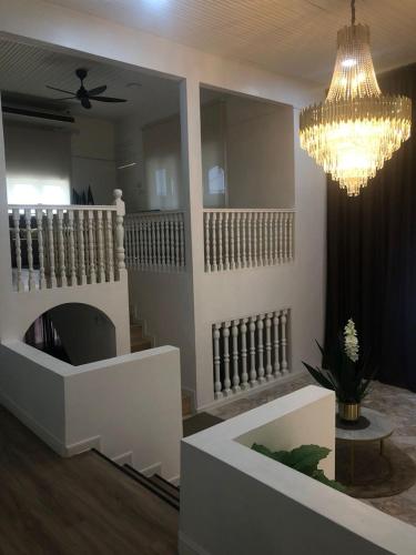 a living room with a fireplace and a chandelier at Calma Villa Jalan Sultanah in Alor Setar