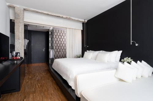 two white beds in a room with black walls at Sala Rattanakosin Bangkok in Bangkok