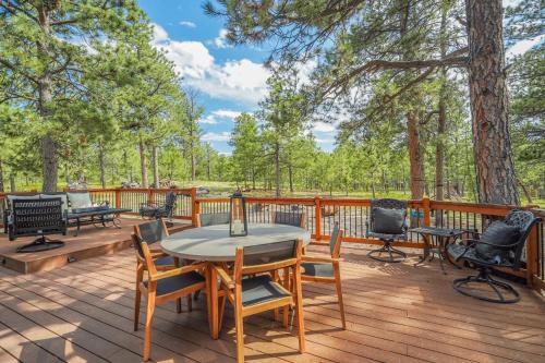 a wooden deck with a table and chairs on it at Buckskin Hideaway Hiking & Biking Trails BBQ in Monument