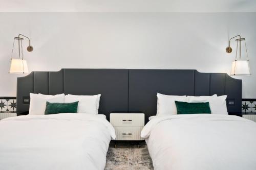 two beds sitting next to each other in a bedroom at Casablanca Inn in San Clemente