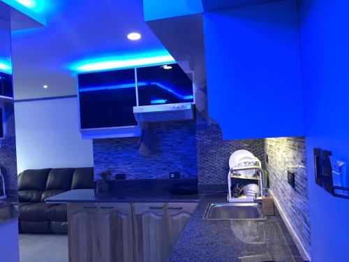a kitchen with a sink and a stove with blue lights at Olivia's Mi Casa in Lapu-Lapu, Cebu in Pusok