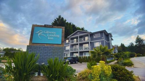 a sign for a resort with a building at Gibsons Landing Inn in Gibsons