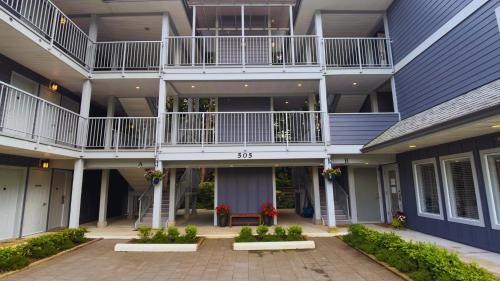 an apartment building with a balcony and a courtyard at Gibsons Landing Inn in Gibsons