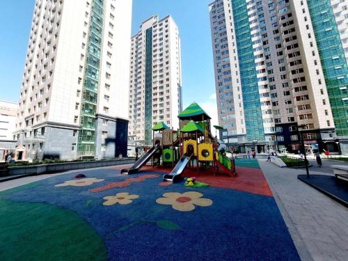 a playground in the middle of a city with tall buildings at National Stadium-Naadam Center-Tsengeldekh apartment in Ulaanbaatar