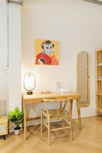 a desk in a room with a painting on the wall at Wabisabi Bangkok 3 MIN To Train Station in Bangkok