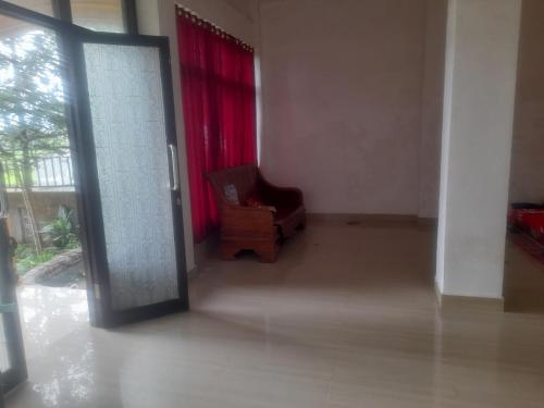 an empty room with a chair and a red curtain at Lombok Happy in Mantang