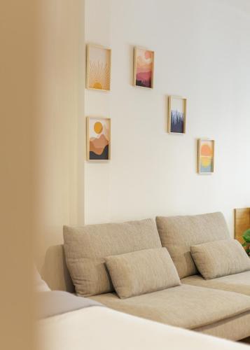 a couch in a living room with pictures on the wall at Wabisabi Bangkok 3 MIN To Train Station in Bangkok