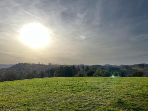 a green field with the sun in the sky at Atempause und erholsame Zeit im Harz in Braunlage