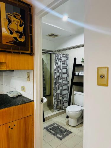 a bathroom with a toilet and a shower at Olivia's Mi Casa in Lapu-Lapu, Cebu in Pusok