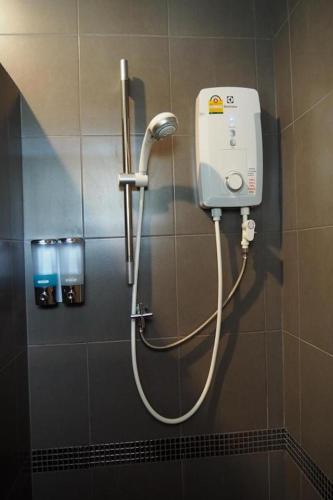 a shower in a bathroom with a hose on a wall at Friendly Hotel Krabi in Ao Nam Mao