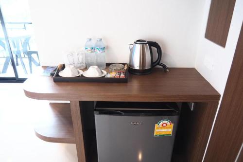 a table with a coffee maker on top of a refrigerator at Friendly Hotel Krabi in Ao Nam Mao
