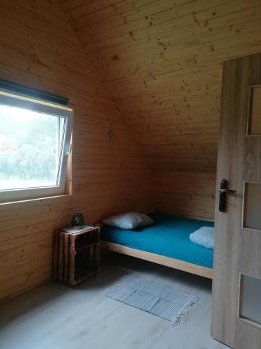 a small room with a bed in a wooden cabin at Lisi Zakątek in Czarna