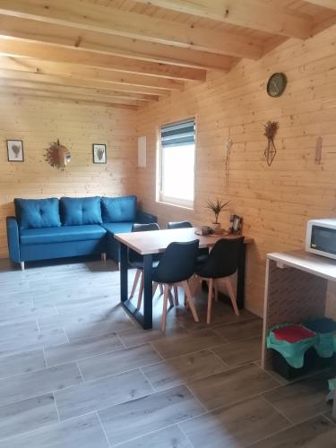 a living room with a blue couch and a table at Lisi Zakątek in Czarna