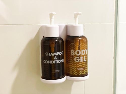two bottles of shampoo and conditioner on a wall at YELLO Hotel Paskal Bandung in Bandung