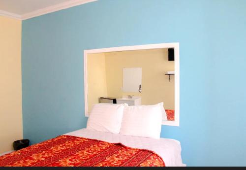 a bedroom with a bed with a large mirror at Plaza Hotel Gardena in Gardena