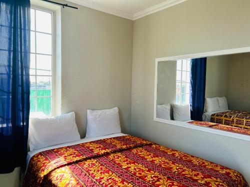 a bedroom with a bed and a large mirror at Plaza Hotel Gardena in Gardena