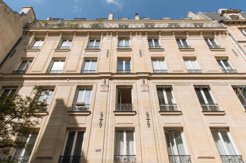 un grand bâtiment bien exposé avec des fenêtres et des balcons dans l'établissement Very Central Studio Apartment for 2 in Paris, à Paris