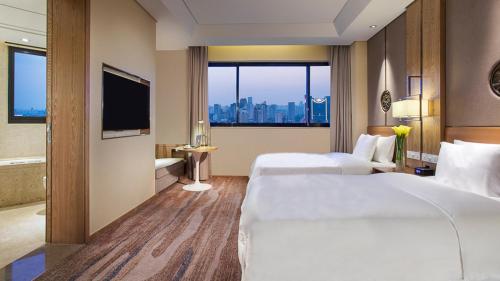 a hotel room with two beds and a large window at Holiday Inn Hefei by IHG in Hefei