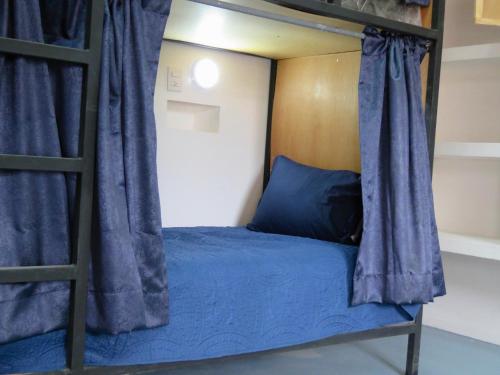 a bedroom with a bunk bed with blue sheets at Hostal Centro Histórico in Oaxaca City