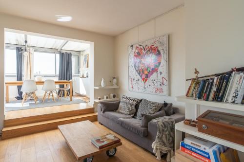 un salon avec un canapé et une table dans l'établissement Breathtaking 2BD Apartment Roof-top Patio 19e!, à Paris