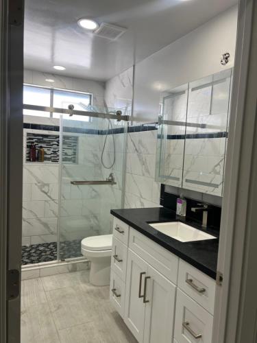 Un baño con ducha, lavabo e inodoro. en Entire home in Lawndale Los Angeles, en Lawndale