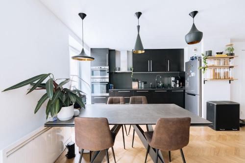 - une cuisine avec une table à manger et des chaises dans l'établissement Le Marais - Modern design apartment, à Paris