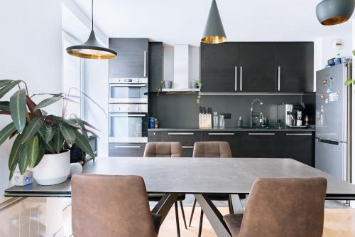 une cuisine avec une table et des chaises dans une cuisine dans l'établissement Le Marais - Modern design apartment, à Paris